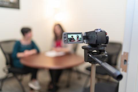 Image of two UNH students practicing interviewing in front of a camera