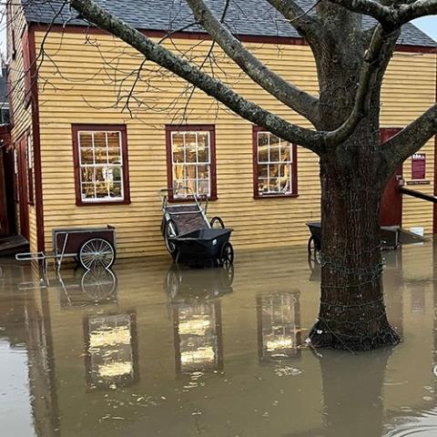 Yellow historic home surrounded by flood waters