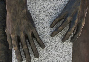 a detail shot of two bronze hands from the sculpture at the African American burial ground memorial in Portsmouth, NH