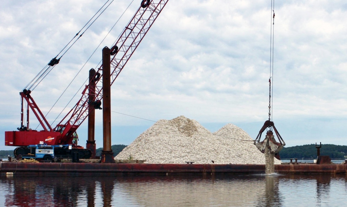 Photo of a crane dumping oysters into Great Bay estuary.