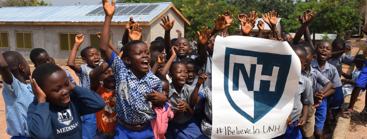 Schoolchildren hold a UNH banner in Ghana