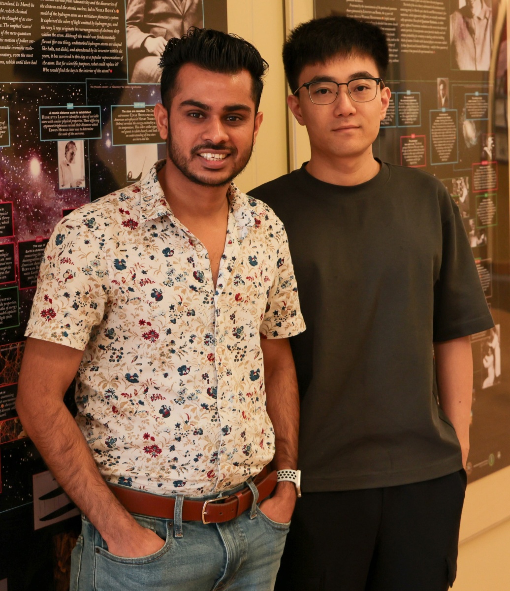 Two young men with dark hair smile at the camera