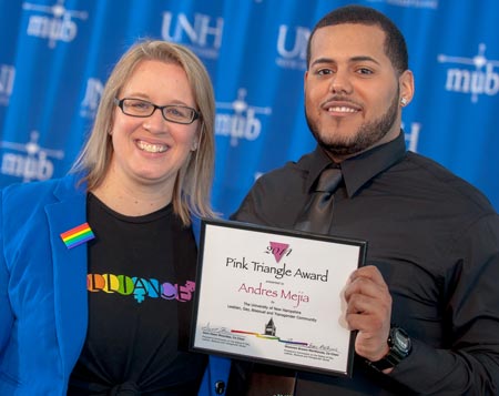 Andres Mejia is presented the Pink Triangle award by Shannon Brown-Marthouse