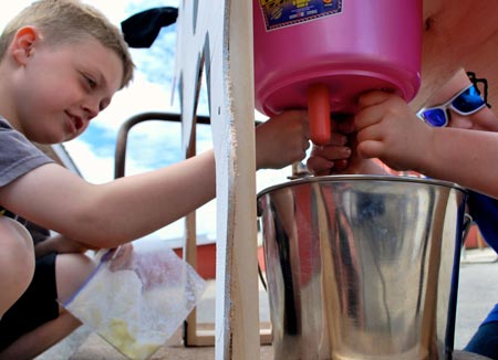 children milking an artificial cow's udder at the CREAM open house