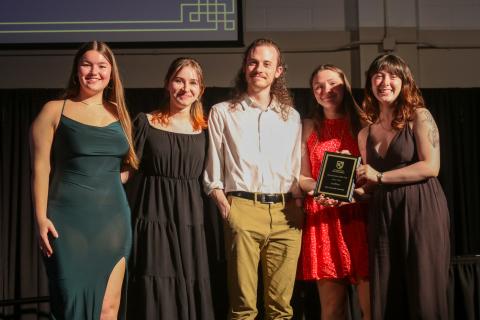 Group of 5 members of the Socratic Society holding a plaque