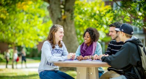 UNH students sitting outside on UNH campus