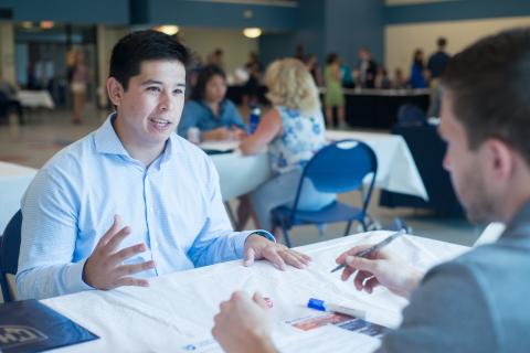 A student meeting with an employer at UNH's Resume Review Day