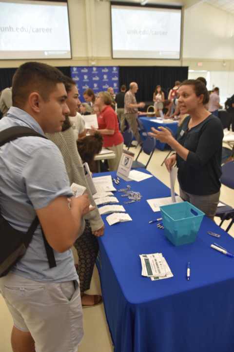 Image of UNH students talking to a UNH department about Work Study at the Part-Time and Work Study Job Fair