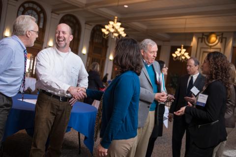 UNH faculty talking in the Huddleston Ballroom