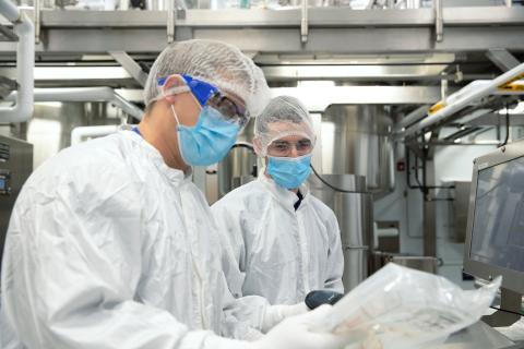 Photo of student and Lonza employee in PPE at Lonza Portsmouth facility