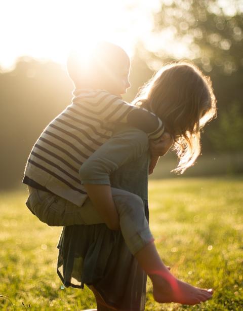 Girl carrying her young brother on her back.