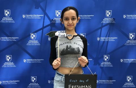 First year student holding sign that says "First day of Freshman Year" and UNH First Gen photo prop