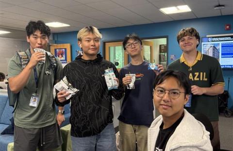 Five students standing with their snacks