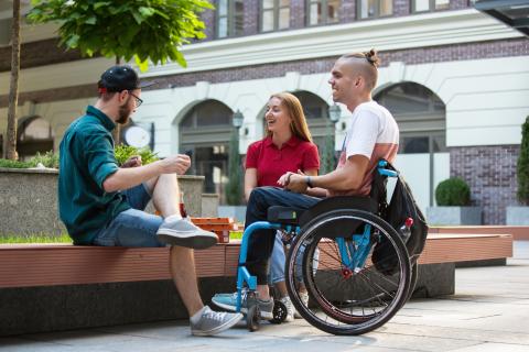 Three students talk on university campus