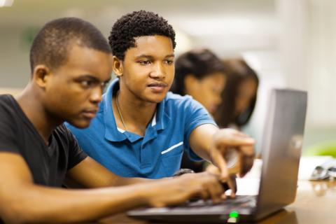 Two students collaborate on computer
