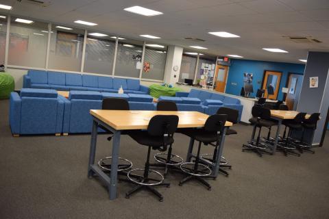 Hightop brown tables with black chairs surrounding them