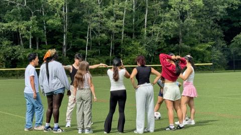 Students standing on a field. Standing in a huddle to discuss before a sports event. 