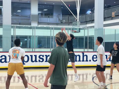 Students playing volleyball on a court. 