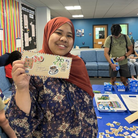 A student holding a handwritten letter to their future selves at a ThirsTea Thursday
