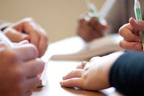 detail of people's hands in the classroom