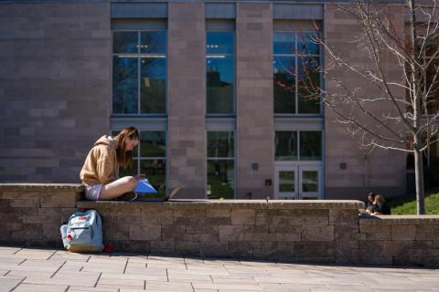 Student sitting in front of Hamilton Smith