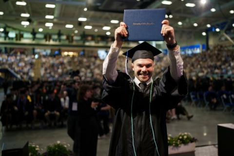 Graduate holding diploma