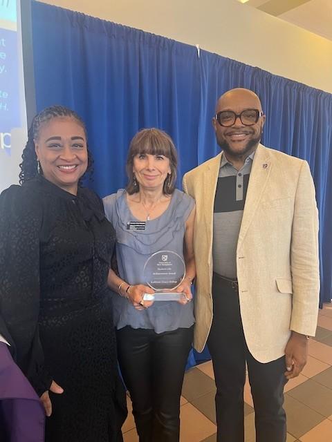 Three people holding an award