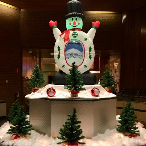 Inflatable Snowman with small Christmas trees around it