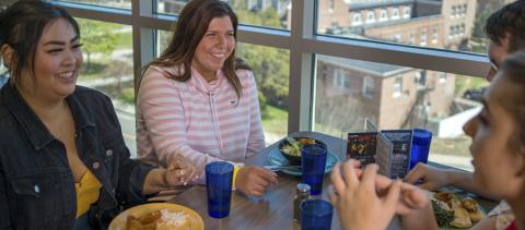 Group of students eating during summer at Holloway Commons