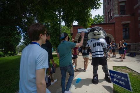 Student high-fiving UNH Mascot
