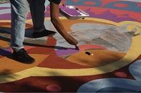 person making making multicolored sand art