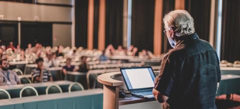 Professor lectures at front of room