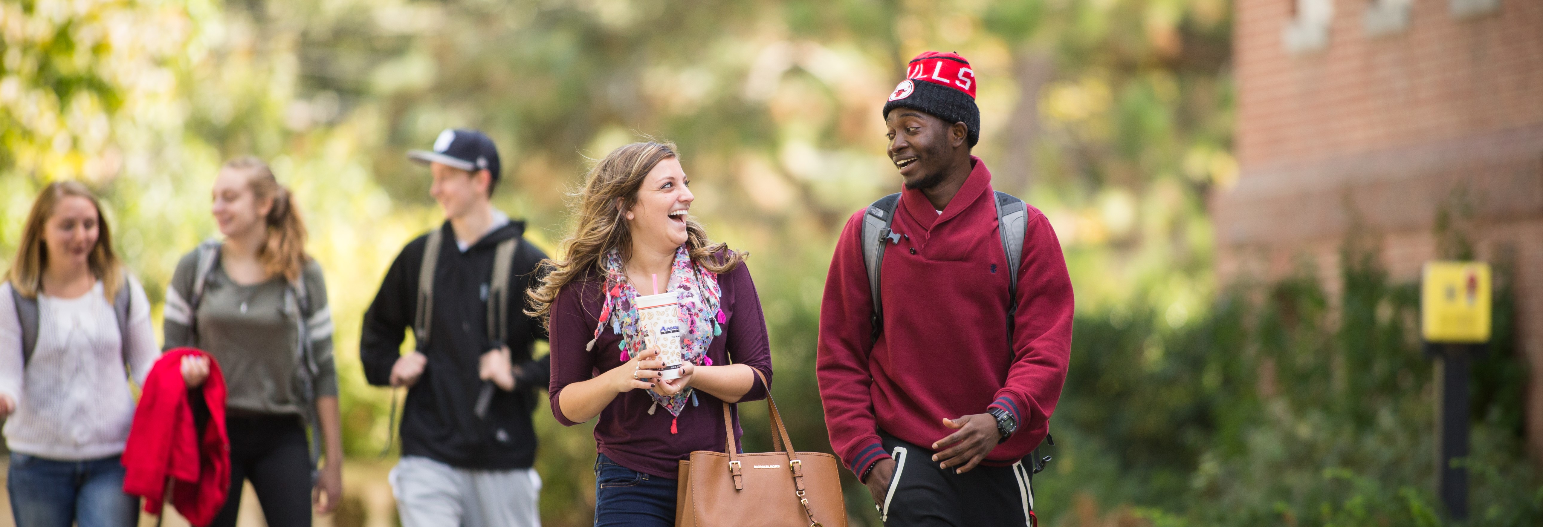 UNH students share a laugh walking to class