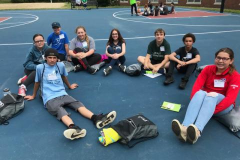 students seated on basketball court