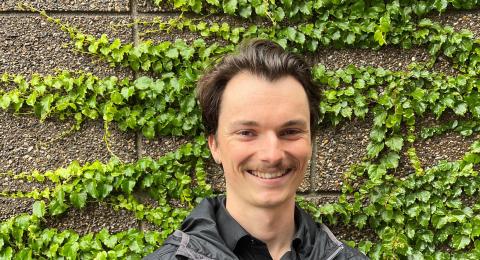 Young man in front of ivy covered wall