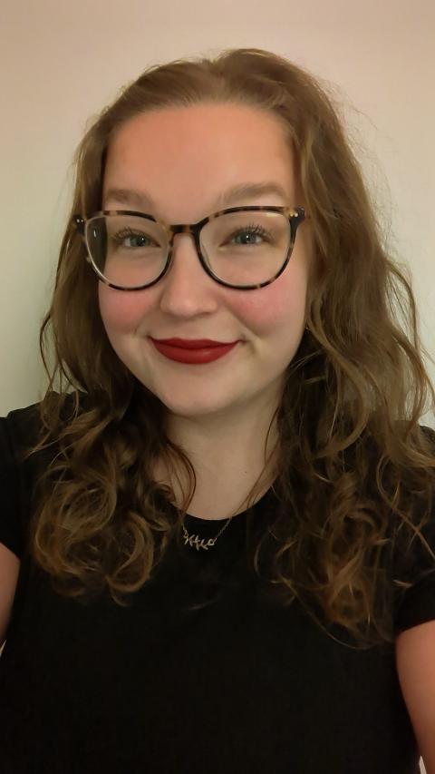 Woman with glasses smiling at the camera