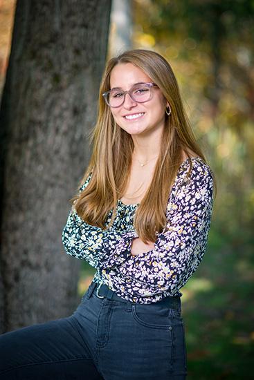 Young woman in front of tree