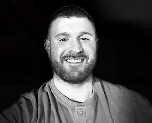Man smiling with dark background
