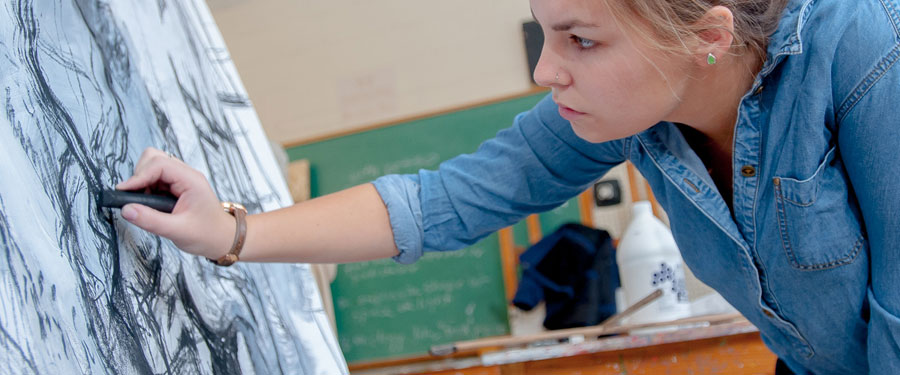 Student drawing with charcoal