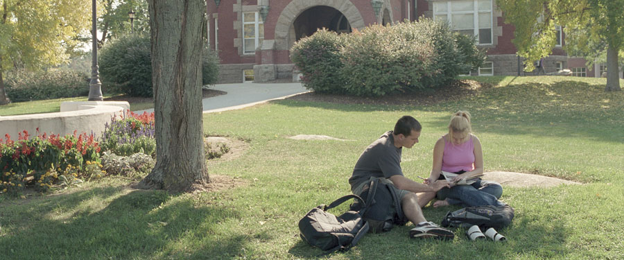 students sitting on t-hall lawn