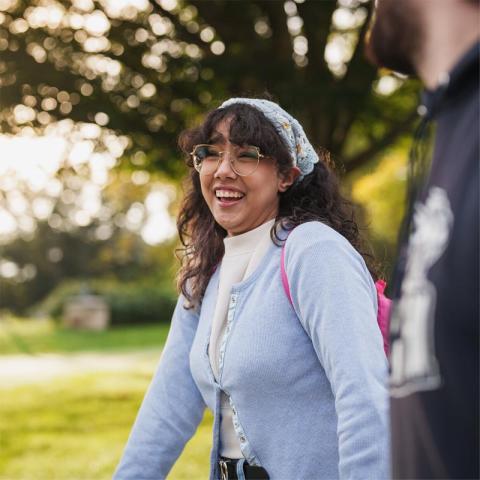 Female student smiling walking outside on campus