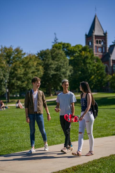 3 students talking on the path outside Thompson Hall