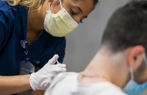 UNH nursing student administering a covid-19 vaccine