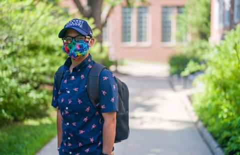 student wearing mask with unh hat 