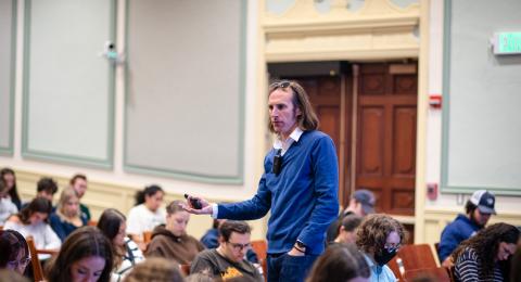 Dr. Paul Robertson teaching while standing in a packed lecture hall 