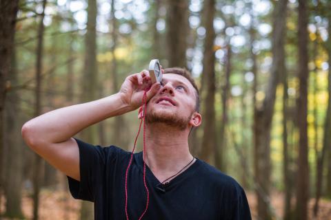 A student collecting forest inventory data using a combination of traditional field tools and current, cutting-edge sampling techniques