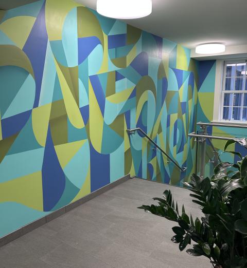 A blue and green mural in a stairwell