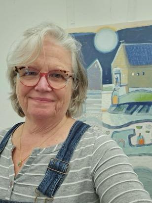 A woman in front of paintings