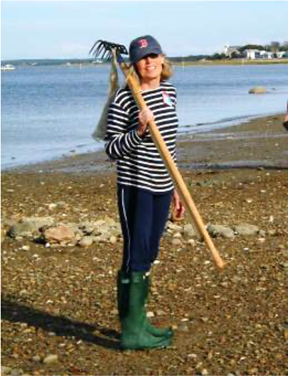 A woman on the beach with a rake
