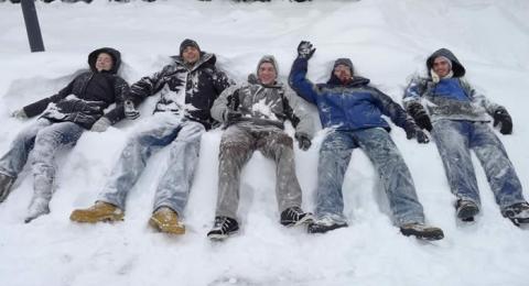 students laying in snow